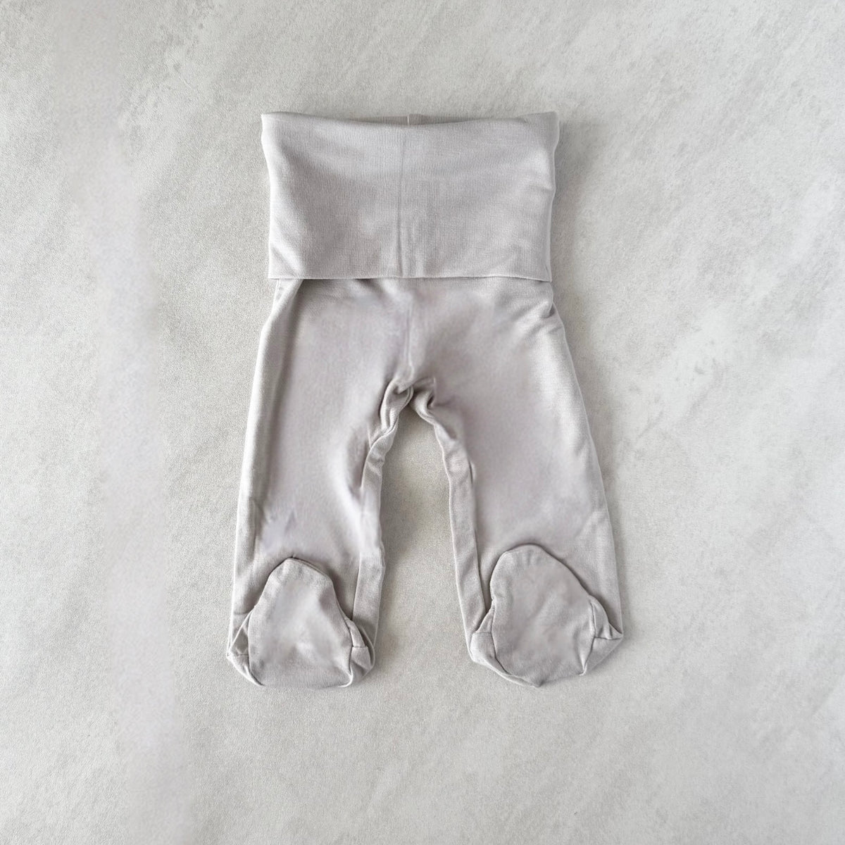 Gray tiny baby bottoms on a light gray background