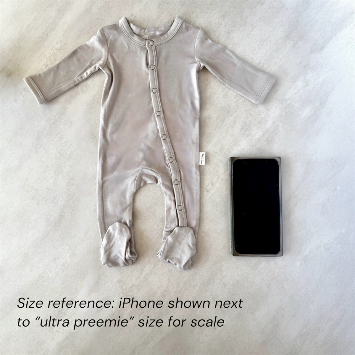 tiny baby clothes for preemie baby shown with phone for size reference